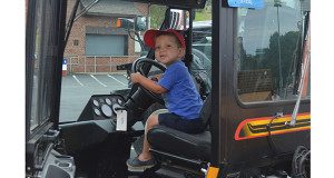 A boy at Needham’s Touch-A-Truck event sits in a construction vehicle.  Photos by Lizzy Collotta