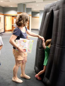 A young girl leads her mother into the Star Lab for an interactive and educational astronomy experience.