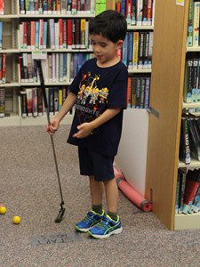Alex and Adrienne (5) of Norwood visit the Islington Branch Library to test their mini golf skills. Photos by Laura Drinan. 