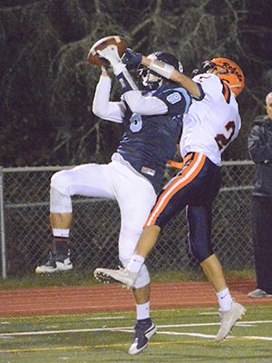 Medfield wideout Jake Dubbs (8) goes up and battles with Walpole defensive back Chase Conrad (2) for a 50/50 ball late in the second half of Friday night’s thrilling 36-30 victory by the Warriors.  Photos by Lizzy Collotta