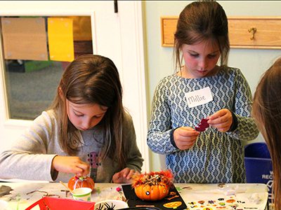 With stickers, glitter, plastic spiders, googley eyes at their fingertips, kindergarten and first graders decorated gourds at one of the Medfield Library’s monthly craft events.
