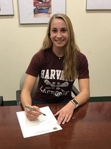 Westwood star athlete Caroline Kremer (pictured) is all smiles after signing her national letter of intent to play lacrosse at Harvard on Thursday. 
