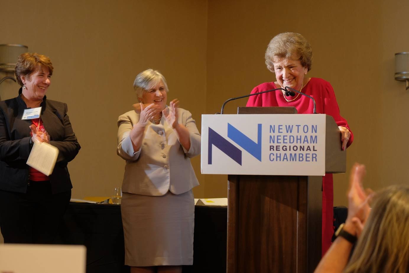 Louise Condon accepts the Newton-Needham Regional Chamber’s honor for decades of unparalleled service to the town at the First Annual Needham Night dinner Jan. 31 at the Sheraton. The award was presented by, from left, Needham Select Chair Marianne Cooley and State Rep. Denise Garlick.... 			
			</div data-eio=