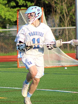 Sophomore attack-man Jimmy Cosolito (11) moves the ball from around X late in the first quarter. Photos by Michael Flanagan