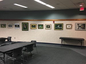 Nelson Hammer’s artwork lining the walls of the Wakelin Room at the Wellesley Library. Photos by Emily Greffenius