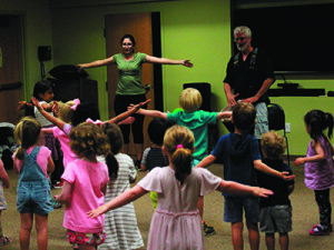 A volunteer from the crowd helps show dance moves to the kids as Norton plays the drums. Photos by Daniel Curtin 