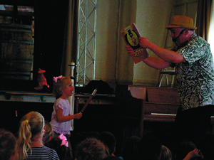 A young volunteer from the audience helps Jim with a magic trick. Photos by Daniel Curtin 