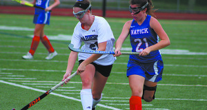 Abigail Gramer (left) fights off a Natick defender on a rush up the field late in the first half.