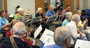 Seniors play the ukulele during a class at the Caryl Center.