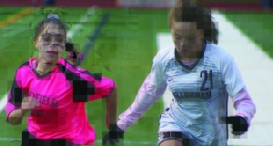 Jillian Diliberto (left) fights off a Bellingham defender in pursuit of a loose ball.