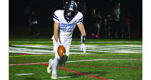 Cameron Lunn (87) boots the ball away for Medfield from deep in his own territory midway through the third quarter.