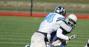Medfield’s Colby Gonser (34) grabs hold of DS running back Tylan Mendes with Camron Giunta (33) closing in for support.