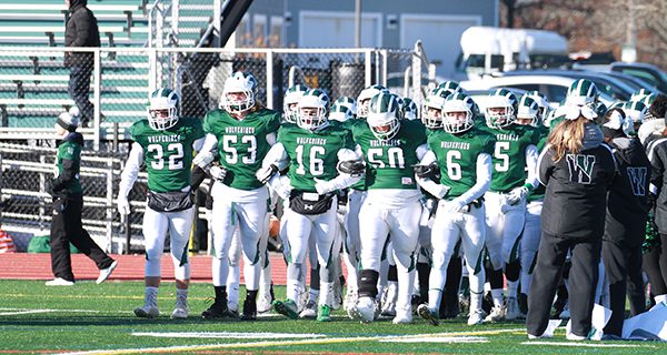 From left-to-right: seniors Dominic Hough (32), Miles Heespelink (53), Eli Maroun, Declan Burke (50), and Braden Loughnane (6) lead the Wolverines out onto the gridiron.   Photos by Mike Mao
