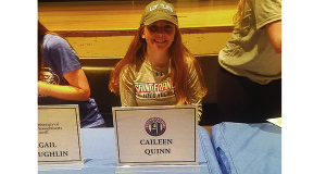 Caileen Quinn (pictured) is all smiles with her new lid and t-shirt after signing to play field hockey at St. Francis. Photos by Twitter, @WalpoleAD