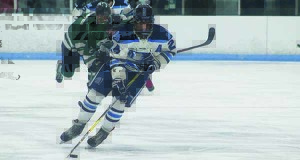 Medfield forward Mike Tyer (24) makes a cut in rushes the puck through the neutral zone.