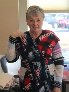 Julie Pinel shows off their last craft, the Patriot’s scarves