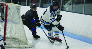 Medfield’s Phil Parker (23) shields the puck from DS/Weston’s Connor Burke (3).