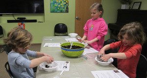 Emma, Brit, and Morgan Madison work hard at making their soil and clay mixture for their seed balls. 