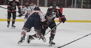 Walpole’s Marc Hirshom and Wellesley’s Joe Fleming collide while battling for a loose puck. 