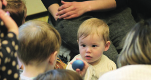 A small child is fascinated by a ball.
