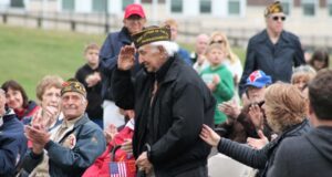 Veteran saluting at memorial service.